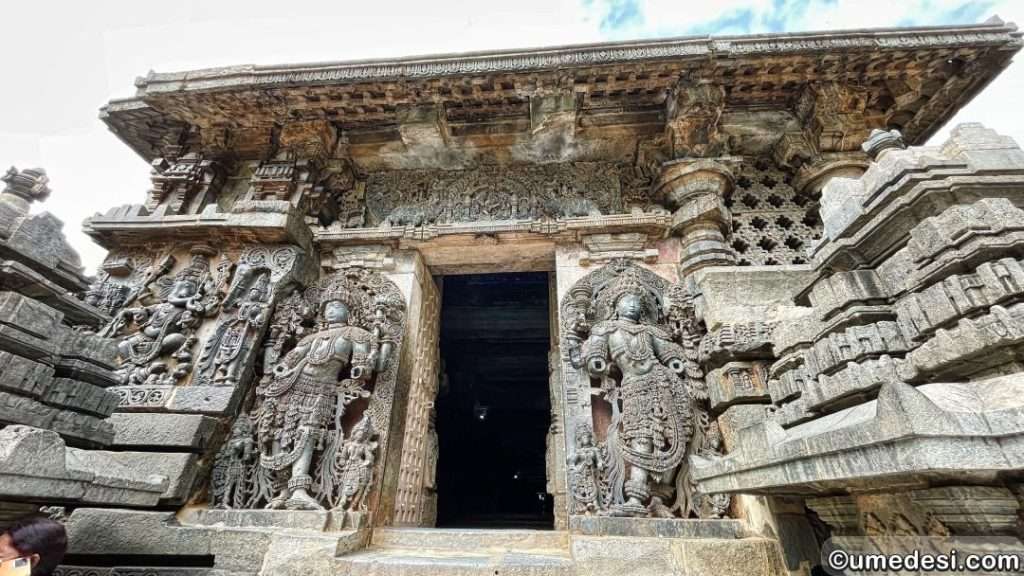 Ornate temple doorway at Hoysaleswara Temple with guardian deity sculptures and intricate carvings.