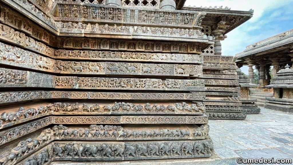Close-up of detailed carvings on the outer walls of Hoysaleswara Temple, depicting mythological scenes.