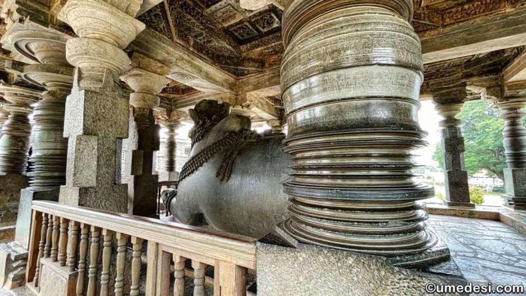 Rear view of the Nandi sculpture at Hoysaleswara Temple with ornate pavilion pillars.
