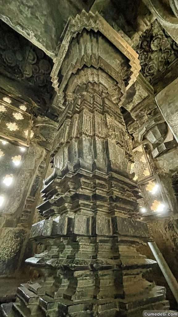 Highly decorated temple pillar showcasing layered geometric designs inside Hoyasaleswara Temple.