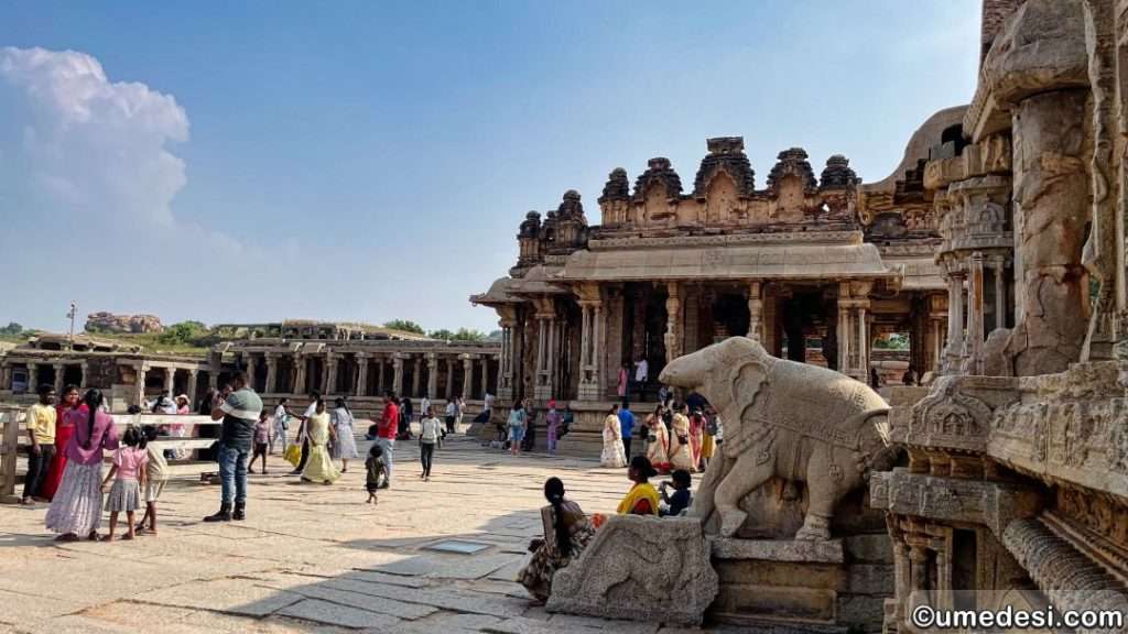 Visitors exploring the courtyard of Vijaya Vittala Temple in Hampi.