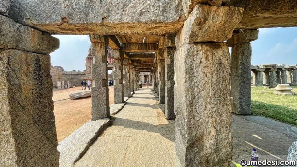 Pathway leading to Vijaya Vittala Temple in Hampi, lined with ancient stone pillars.