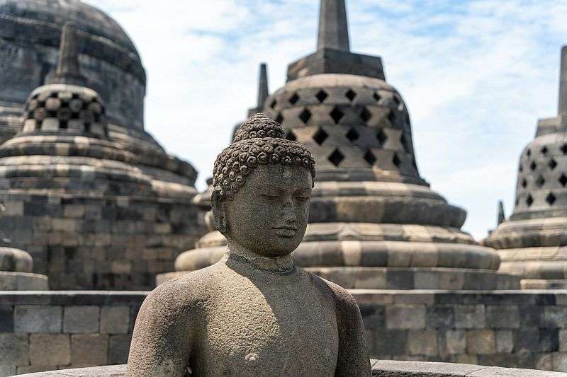 A close up view of one of the many statues of Buddha on the top terraces of Borobudur